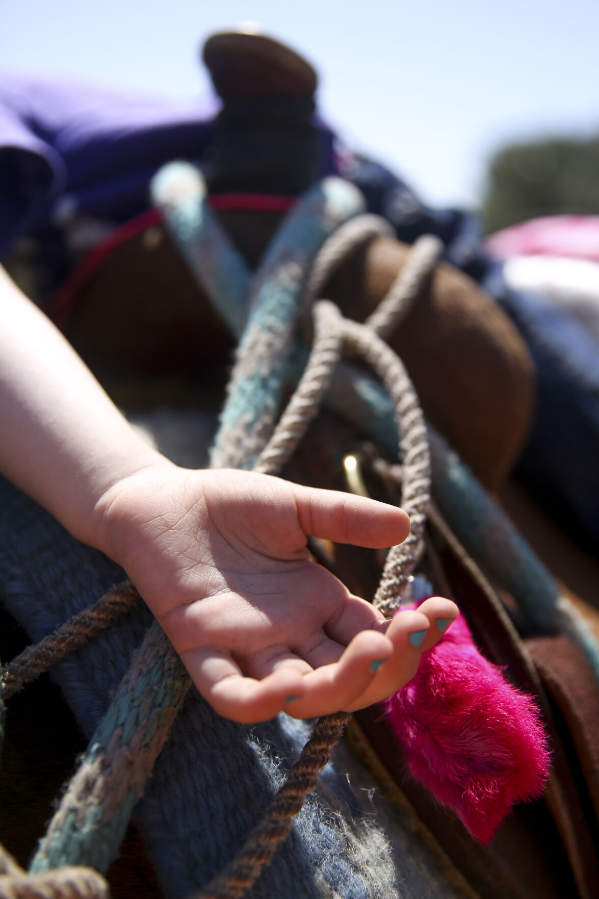 Ellie Greub, 4, lays sideways onto her moms leg from atop her horse
